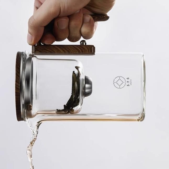 Theekan met doorloopfilterin hand