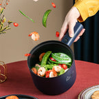 Blauwe elektrische hotpot met deksel in hand